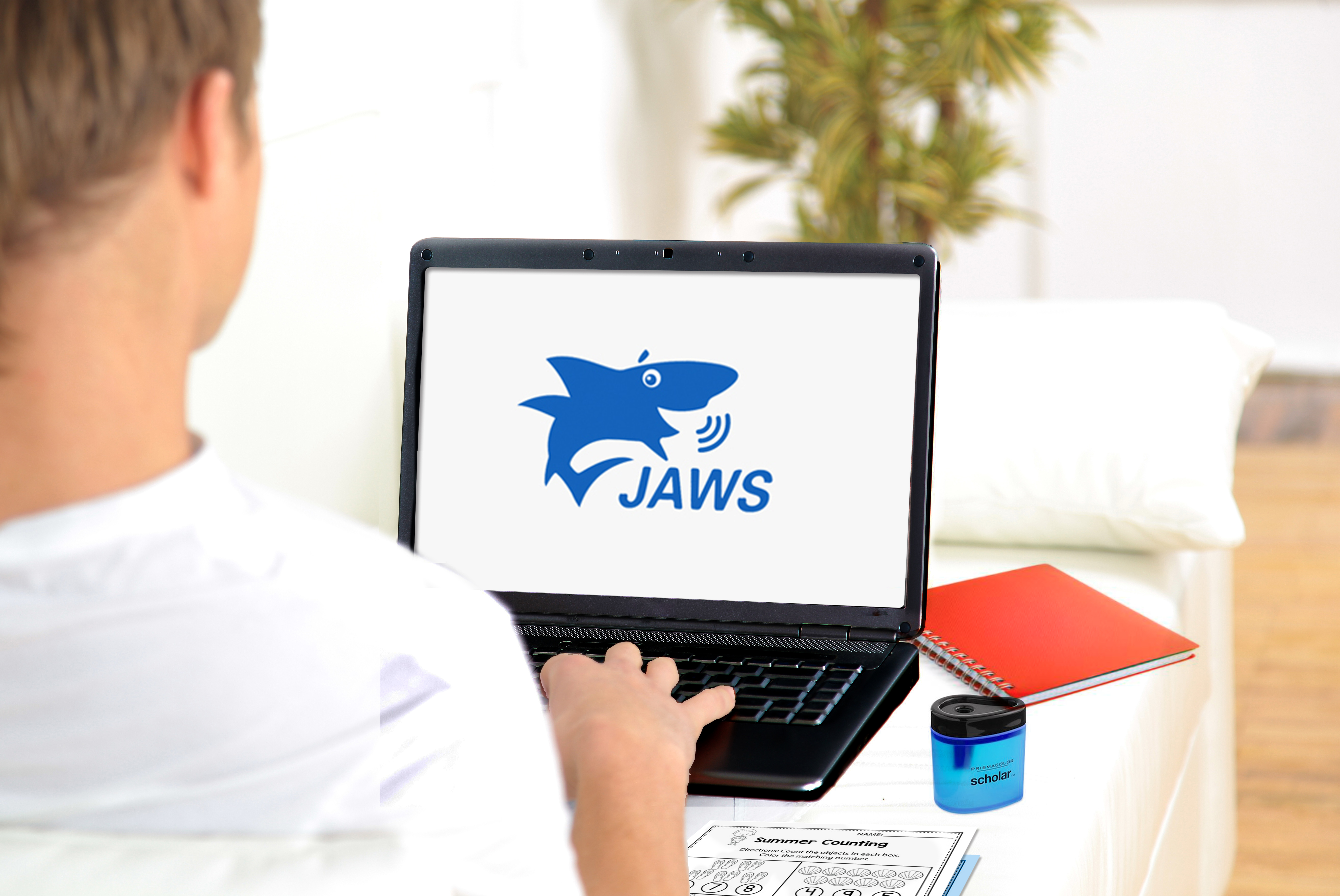 Student on computer with JAWS screen reader logo on screen