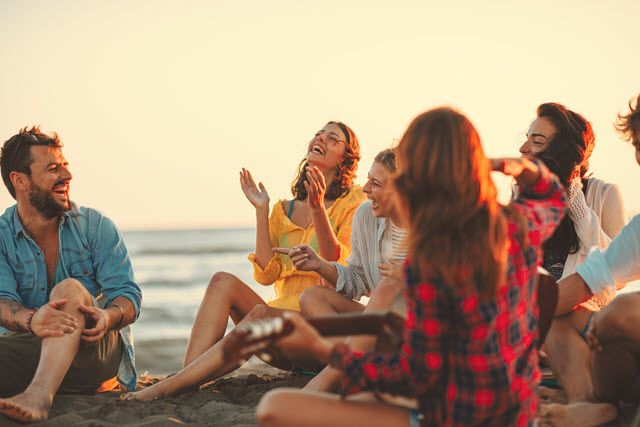 Photo of a group of people sitting on a beach to demonstrate Picture Smart. See detailed description below.